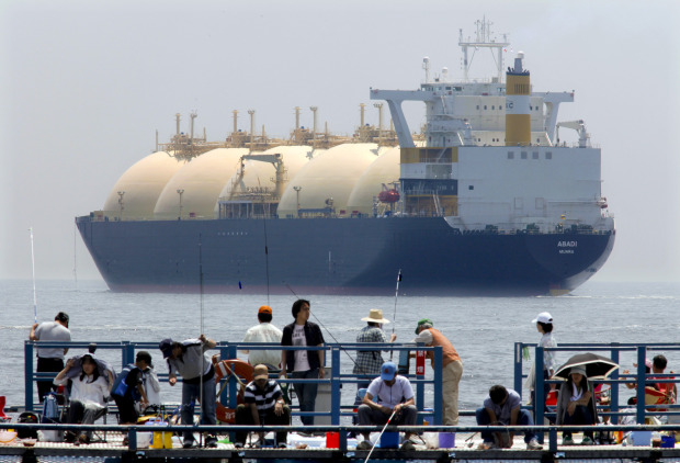 A liquefied-natural-gas (LNG) tanker, leaves a berth as holidaymakers fish on a pier in Yokohama City, Kanagawa Prefecture, Japan, on Saturday, June 20, 2009. The world LNG market is likely to face supply shortages around 2013 as new projects fail to keep pace with supply, according to Wood Mackenzie, a U.K. energy research and consulting company. Photographer: Kimimasa Mayama/Bloomberg News