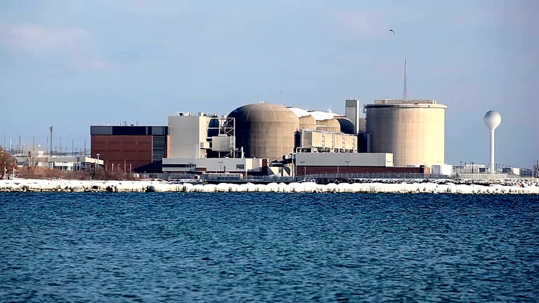 "Pickering nuclear generating plant on the shore of Lake Ontario just east of Toronto. This large nuclear facility is comprised of eight reactors and provides as much as 20% of Ontario's nuclear needs, enough to serve a city of two million people. It is co-located with a single wind turbine."